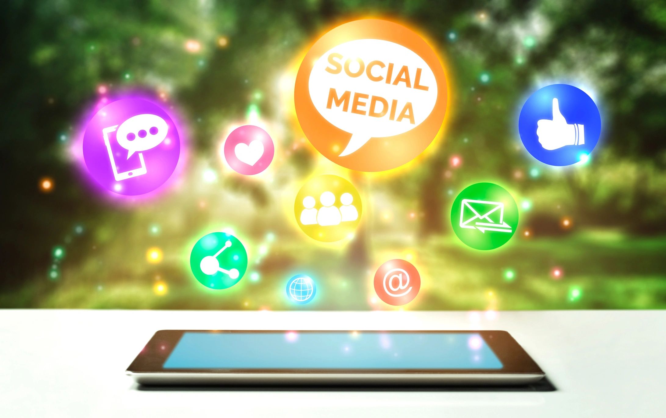 Tablet with colorful social media icons floating above it.