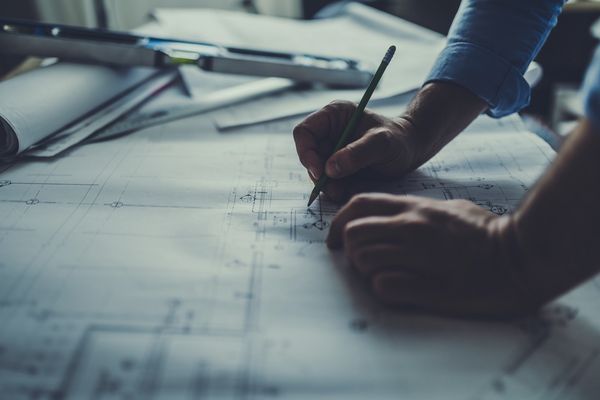 Blueprints and drafting tools on a desk.
