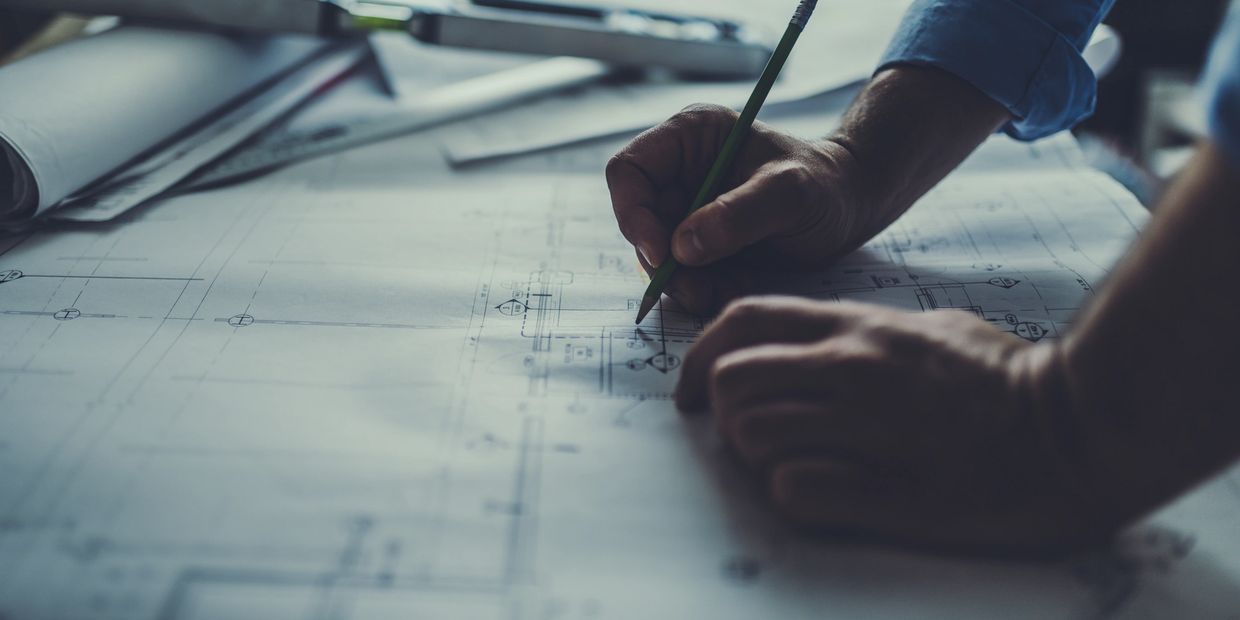 Architect utilizing drafting tools in a modern workspace.