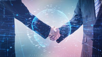 Two business professionals shake hands with a digital globe and data overlay.