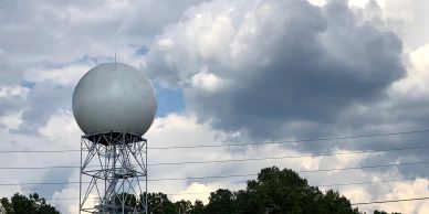 Large radar dome under cloudy sky.