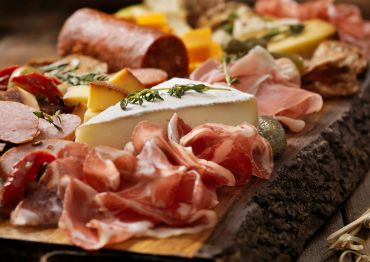 Planche apéritive avec fromages et charcuteries variées.