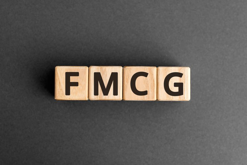 FMCG - acronym from wooden blocks with letters, fast moving consumer goods FMCG concept,  top view on grey background