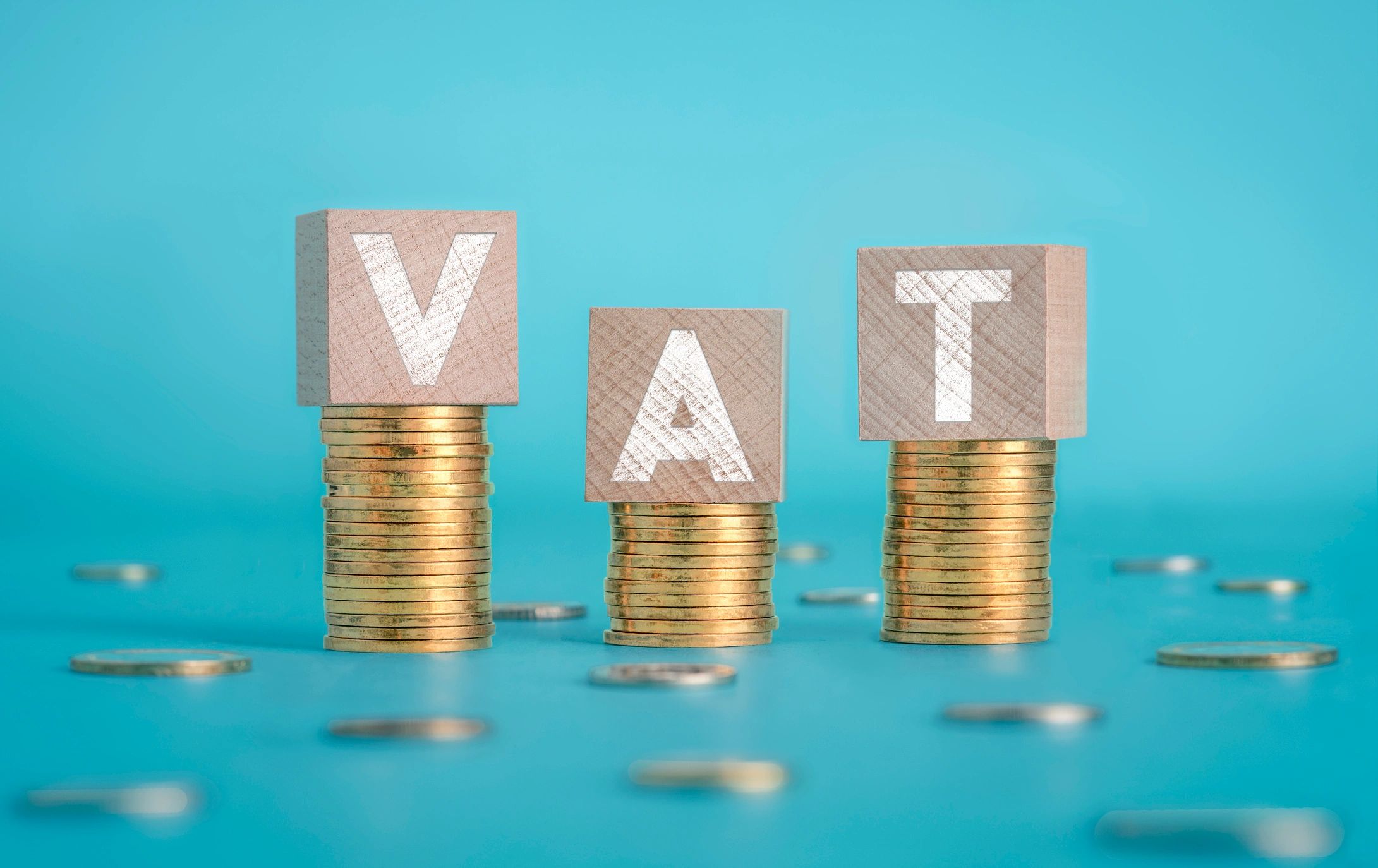 Coins stacked beneath VAT blocks, representing VAT registration, VAT returns and HMRC compliance sup