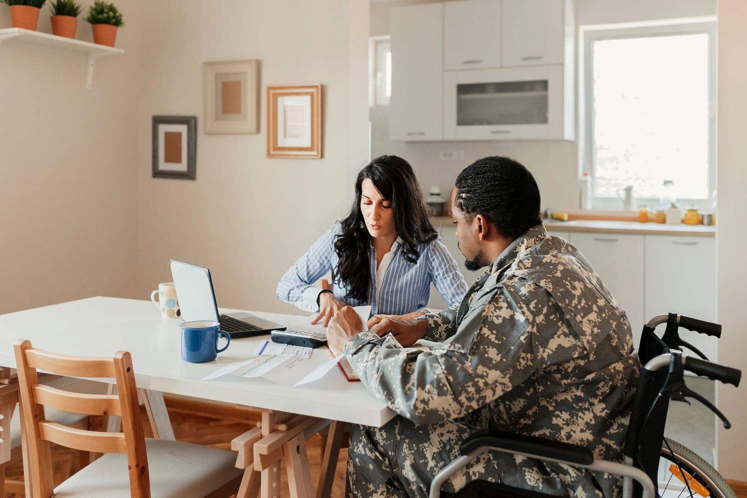 Black pencils in a gray holder next to a stack of white magazines with a camera in the background.