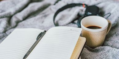 notebook and coffee cup on blanket