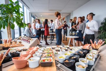 Office party with appetizers and people socializing in a modern setting.