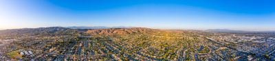 Panoramic aerial view of a sprawling suburban area at sunset.