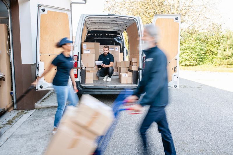 Blurred motion of independent gig delivery team moving with speed to load and unload packages for transport.