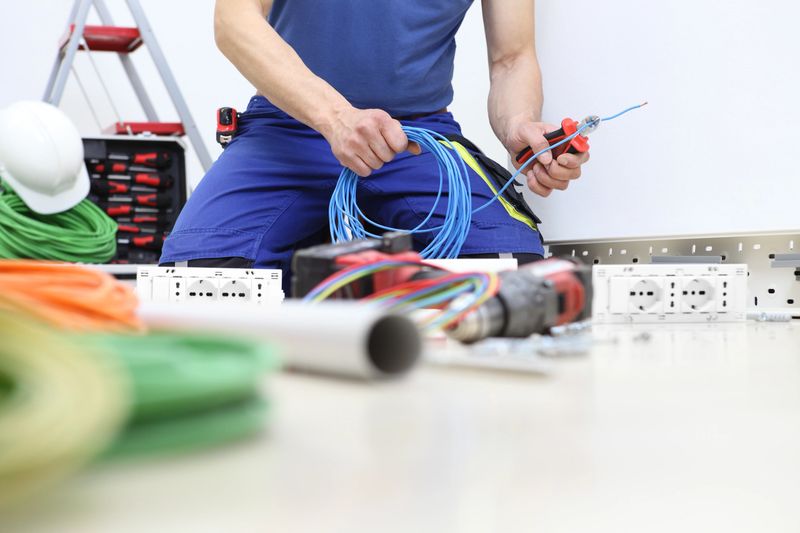 electrician at work with nippers in hand cut the electric cable, install electric circuits, electrical wiring