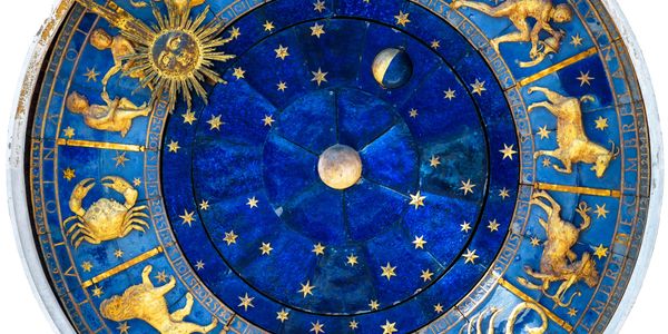 Blue and gold zodiac wheel with astrological symbols and phases of the moon.
