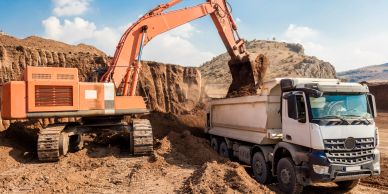 Excavator loading soil into a dump truck.