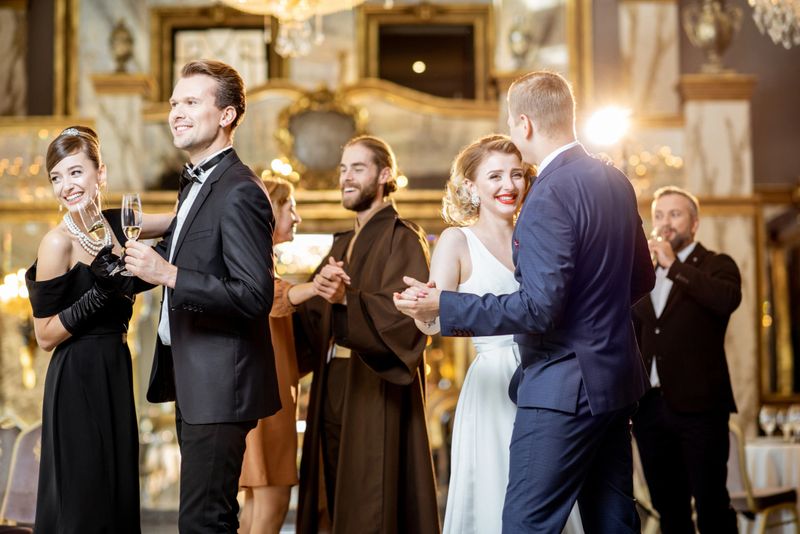 Group of elegant people well-dressed in retro styles dancing at the luxury dance hall during the grand celebration