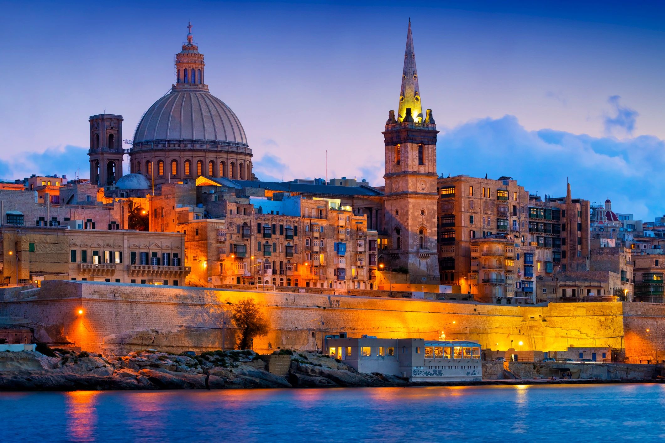 Sunset view of historic cityscape with domed and spired buildings.