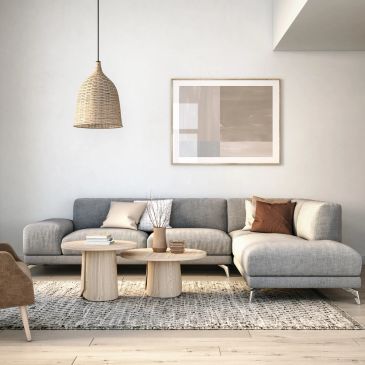 Modern living room with gray sectional sofa and wooden tables.