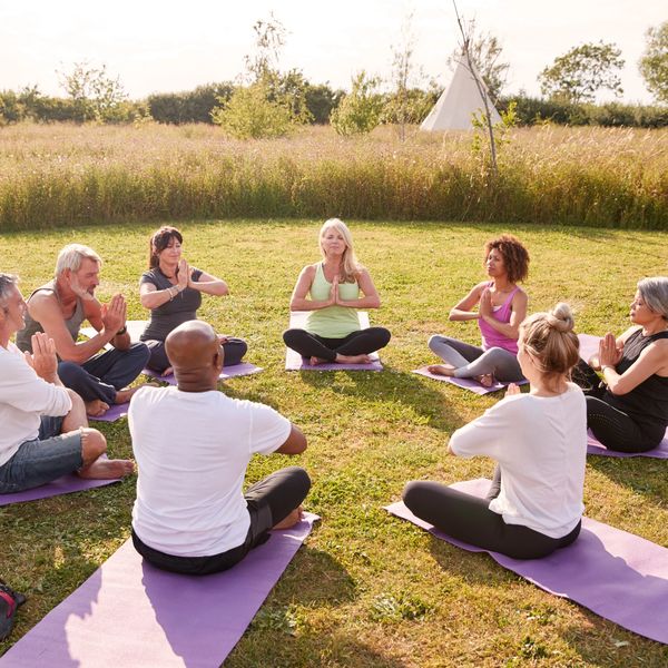 A group of people doing yoga in a field