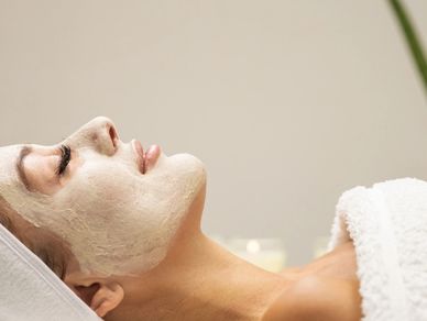 Woman relaxing with facial mask at spa.
