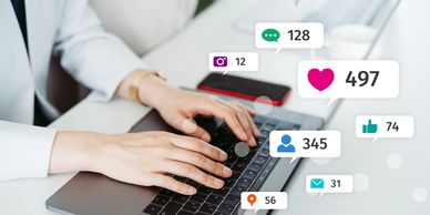 person typing at computer with marketing graphics representing las vegas social media management