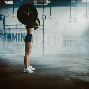 Person lifting a heavy barbell in a gym.
