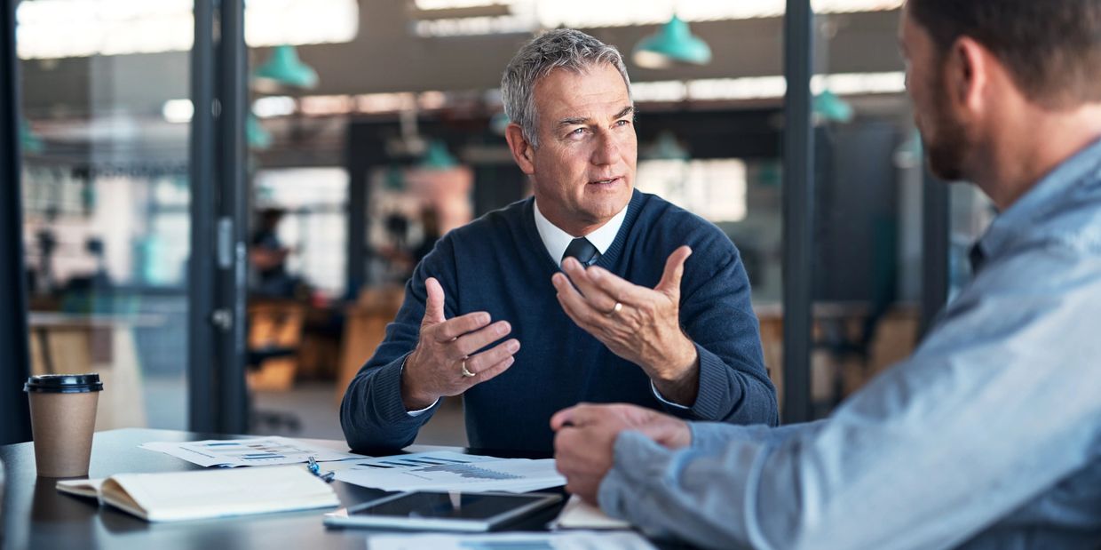 Two men engaged in a business discussion in an office.