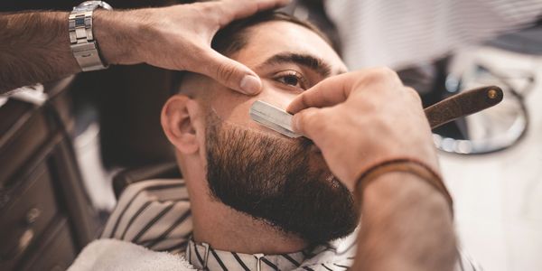Straight razor being used to trim beard in Spring, TX at Empire Barber & Beauty Salon.