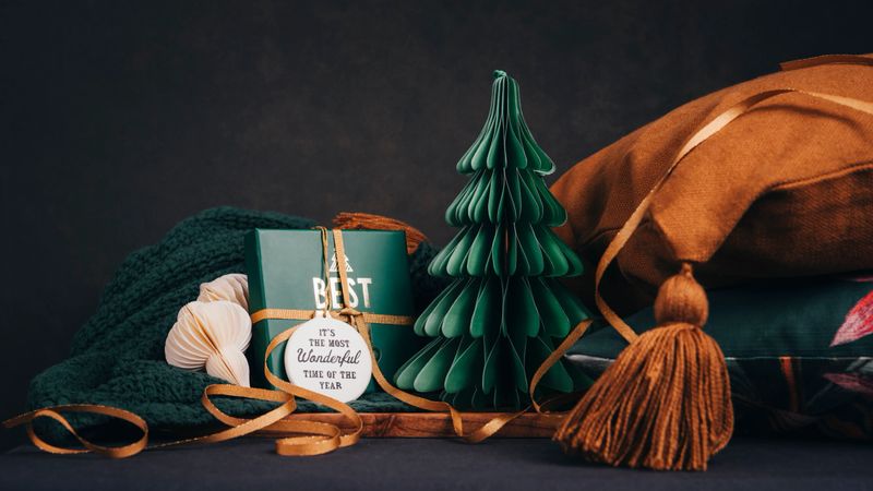 Christmas still with christmas gift and tree with home textiles 
Soft home interior gifts arrangement