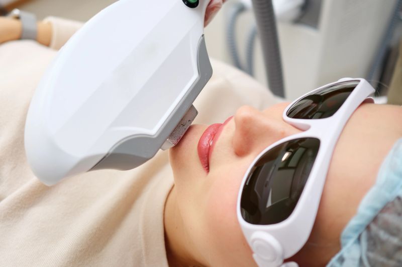 smiling girl client gets rid of excess hair with multi-functional device on laser therapy course selective focus