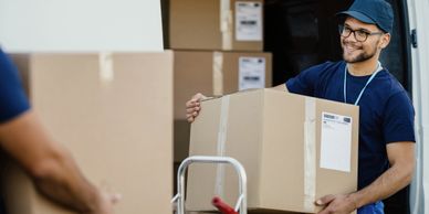 Smiling delivery worker unloading boxes from a van.