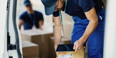 Courier scanning a parcel in a van.