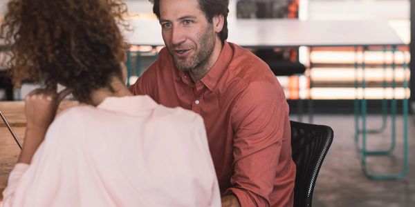Two colleagues having a focused discussion in a modern office.