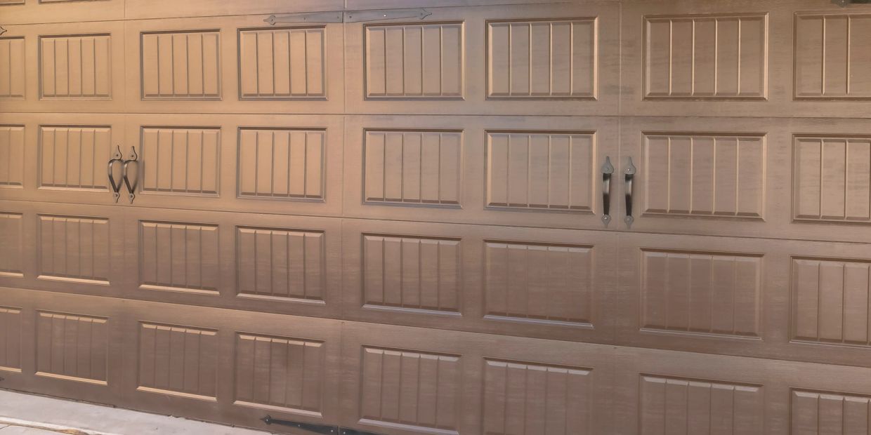 Closed brown garage door with two sets of handles.