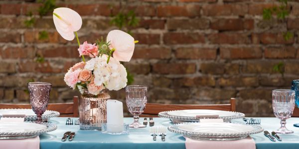 Elegant outdoor table setting with flowers and glassware.