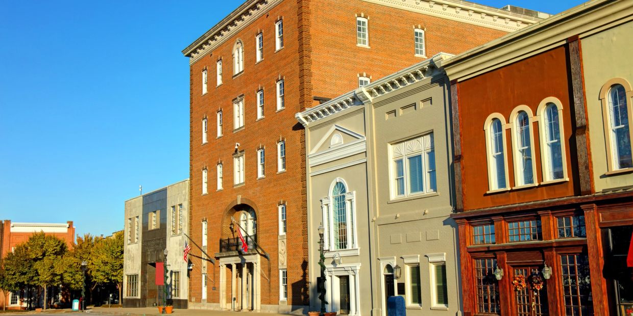 Historic buildings on a sunny street with clear blue sky.