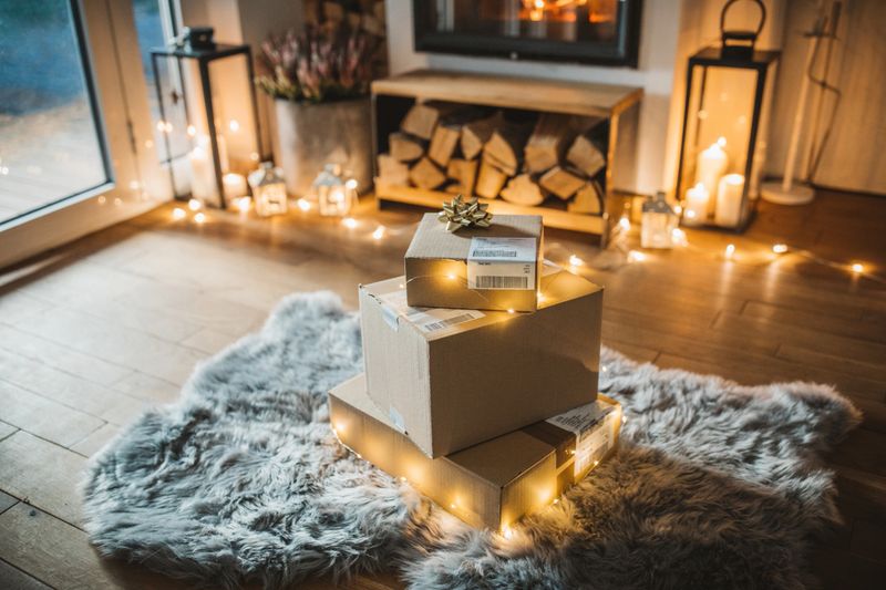 Cozy living room winter interior with fireplace, presents ordered online and delivered wait in front of fireplace.