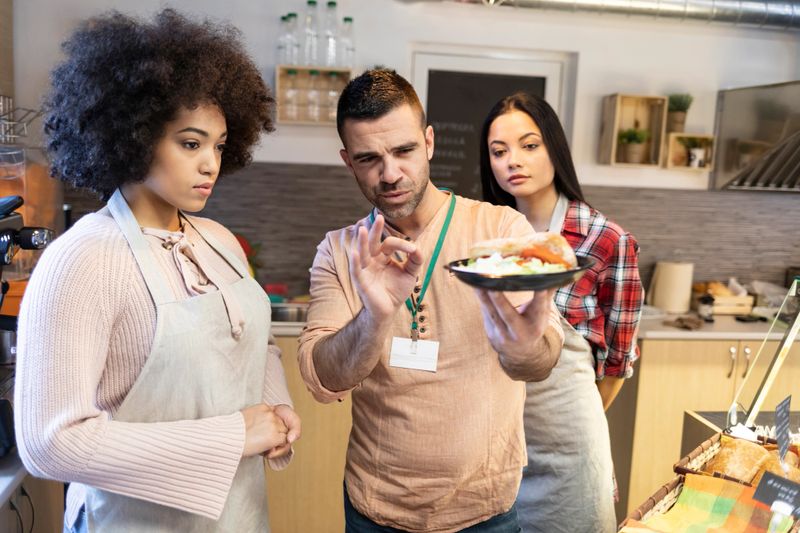 Chef showing to trainee how to make presentation of food.