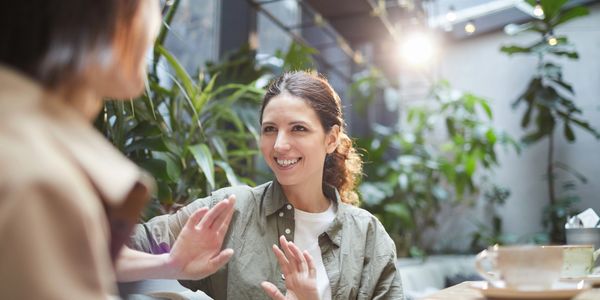Two women having a friendly conversation in a bright setting.