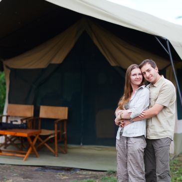 Couple hugging in front of a tent.