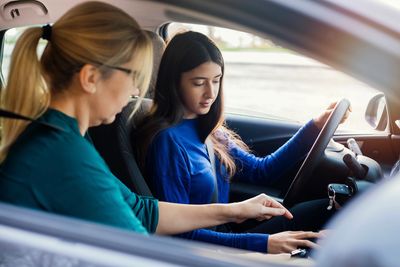 Driving instructor teaching a teenager to drive.