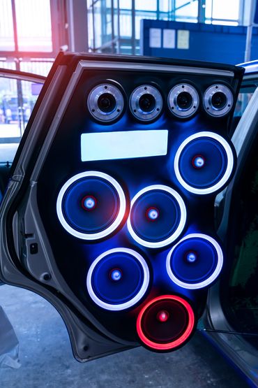 Car door equipped with multiple illuminated speakers for powerful sound.