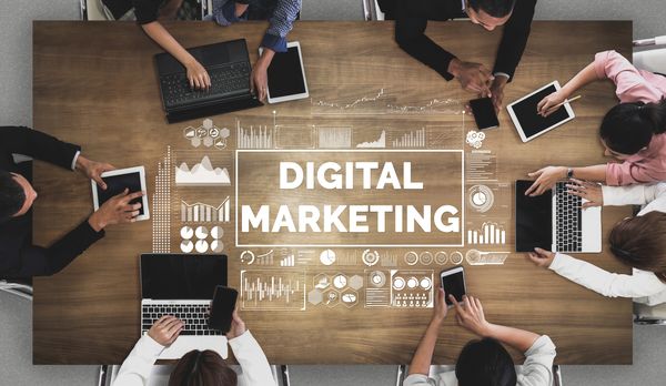People using devices around a digital marketing concept.