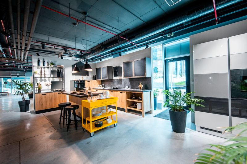 A modern looking design of a kitchen with a single isle as a part of a display in a home design store.