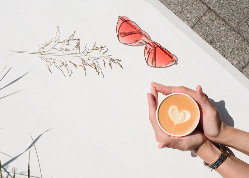 Woman's hands holding cup of coffee or tea on a white background. Top view polystyrene coffee mug. Outdoor.Take away. Advertising coffee. Add your text.