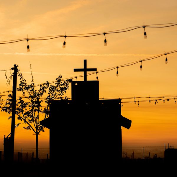 Silhouette of a church with a cross at sunset.
