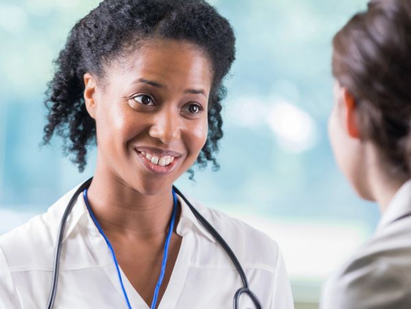 A female doctor smiling and talking to a patient.