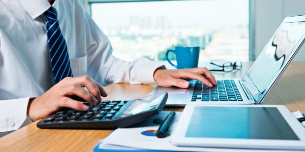 Person using calculator and writing on paper.