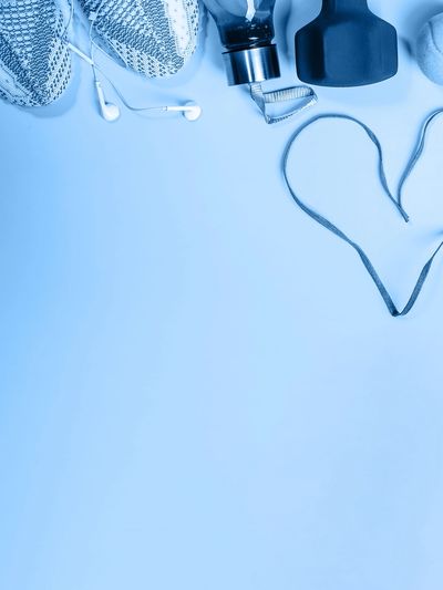 Fitness gear and heart-shaped jump rope on blue background.