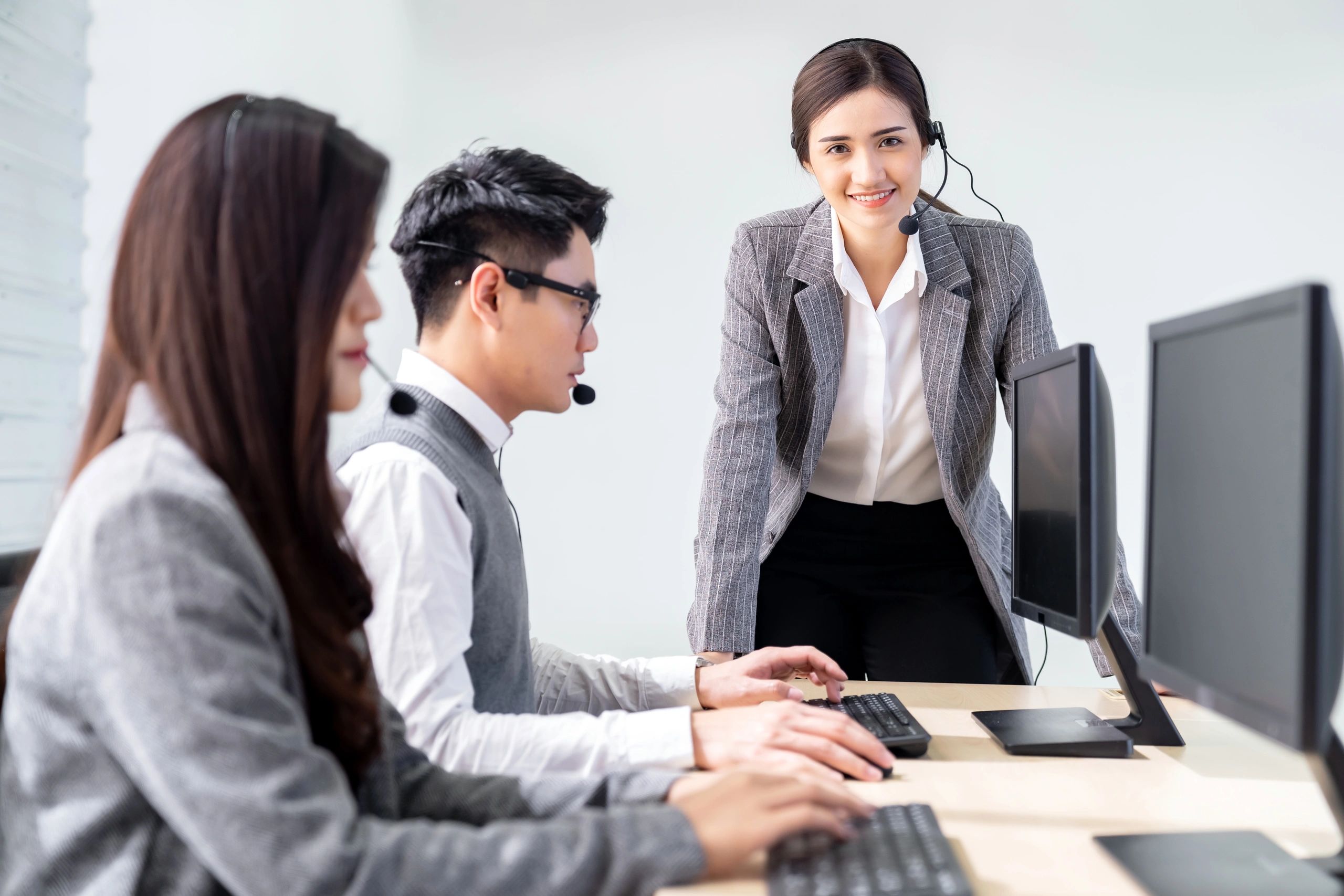 Customer support team working with headsets in an office environment.
