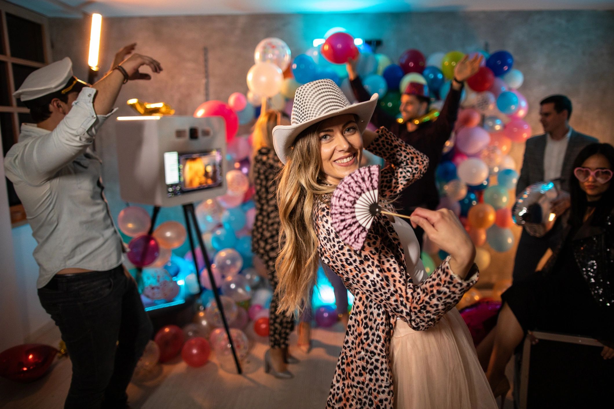 Guests posing for a rotating photo booth camera at a celebration. Illustrative stock image.
