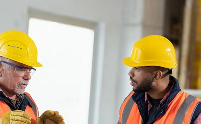 man teaching another man safe use of grinding/ abrasive wheel equipment in accordance with PUWER