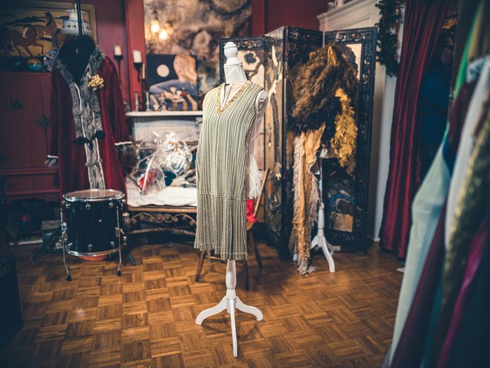Cream knit cardigan with pearl necklace on a mannequin in a store window.